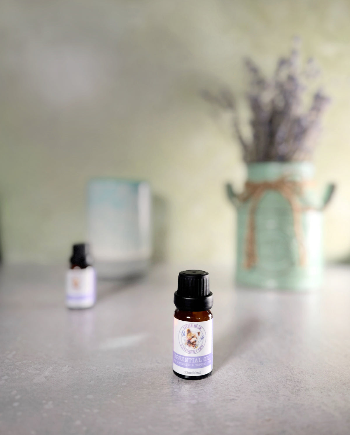 10 ml bottle of steam-distilled lavender essential oil beside lavender
